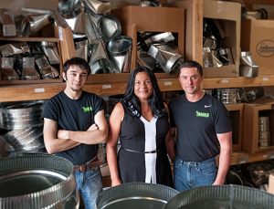 three people in a warehouse storing metal parts