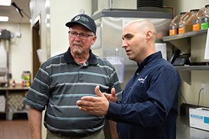 Energy Trust representative and customer talking in the kitchen at the Oregon Veterans' Home during a walkthrough survey.