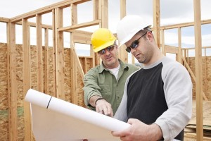 two builders reviewing blue prints for new homes