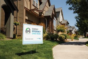 a housing community with a sign out front reading energy efficiency lives here